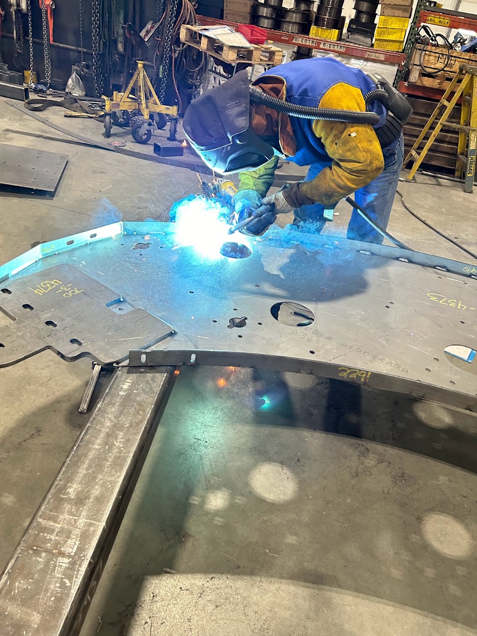 A welder working a steel part on the Alloway shop floor